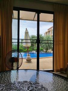 Ban Mae NamApartment的一间设有桌子并享有游泳池景致的客房