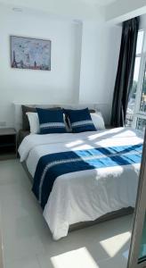 清迈一室一厅宁静舒适公寓清迈市中心的窗户客房内的一张蓝色和白色的床