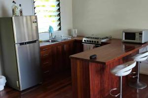 维拉港Dream Cove Cottage, 2 Bedroom的厨房配有不锈钢冰箱和木制橱柜