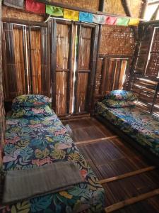 Beran-kidulWaitHozz的铺有木地板的客房内的两张床