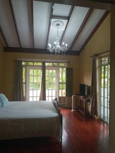 PétionvilleLes Residences Etang Du Jonc的一间卧室配有一张大床和一个吊灯。