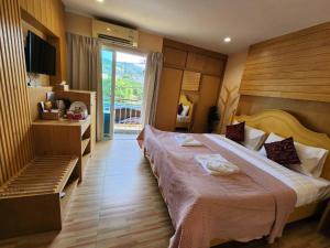 芭东海滩Alaita Hostel Patong的酒店客房设有一张大床和一台电视。