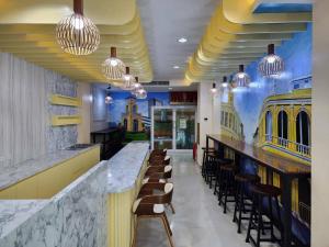 芭东海滩Alaita Hostel Patong的餐厅设有配备椅子和灯的酒吧