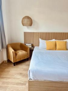 格兰岛Thandara kohlarn的一间卧室配有一张床和一把椅子
