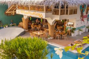 长滩岛Happiness Hostel Boracay的一间带桌椅和游泳池的餐厅