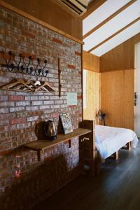 埔里红砖642民宿 的一间设有砖墙、一张床和一张桌子的房间