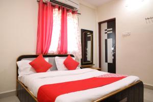 DhantoliOYO Prithvi Inn的一间卧室配有一张带红色枕头的大床