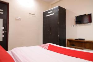 DhantoliOYO Prithvi Inn的一间卧室配有一张床和一个带电视的梳妆台。