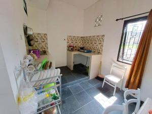 玛琅Villa Murah di Malang的一间带书桌和冰箱的小厨房