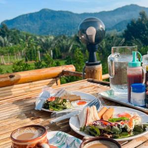 Ban Pa LauQuality Time Farmstay: River House的木桌上放两盘食物,享有美景