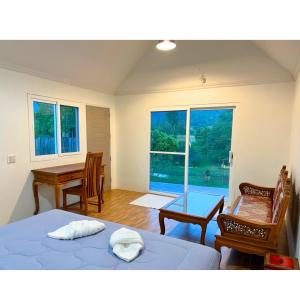 Ban Pa LauQuality Time Farmstay: River House的一间卧室设有两张床、一张桌子和一个窗口。