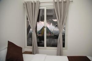 阿勒皮Havana Beach House的一间卧室配有床和带窗帘的窗户