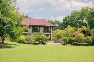 瓜埠Singgahsana Villa的前面有绿色草坪的房子