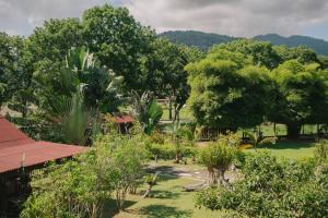 瓜埠Singgahsana Villa的一座种有树木和草地的花园,一座建筑