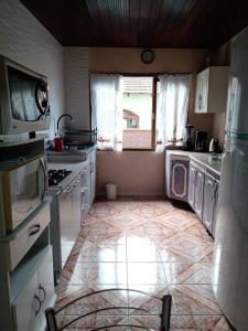 约恩维利Casa linda e aconchegante para hóspedes.(Studio)的铺有瓷砖地板,设有带洗衣机和烘干机的厨房