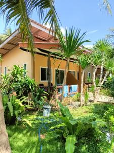 高兰海贝壳海滩度假村 的庭院里棕榈树的房子