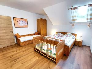 FerschnitzLandhaus Schaidreith的一间卧室配有两张床和一张婴儿床。