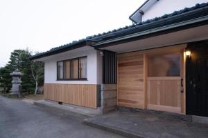 长野Kominkahu kashikiri cottage Tokei - Vacation STAY 57497v的一座带木门和窗户的房子