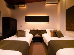 富士吉田市SWEET VILLA TAKASAMA的客房设有两张床和一台平面电视。