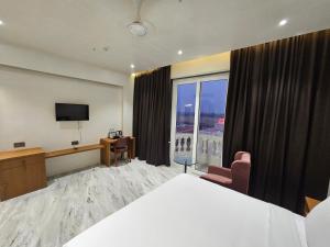 索姆纳特The S Crown Somnath的酒店客房设有一张床和一个大窗户