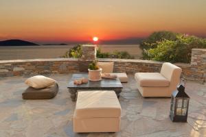 马尔马里Wavefront Serenity - Exotic & Dreamy Getaway的一个带桌椅的庭院,享有日落美景。