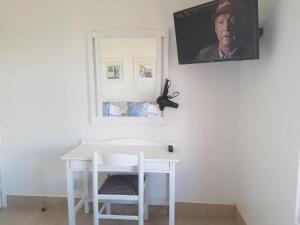 兰格班358 Kaliva - Club Mykonos的一张白色的桌子,墙上挂着一张男人的照片