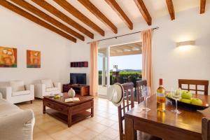 苏昂博Villas Menorca Sur的一间带桌子的客厅和一间餐厅