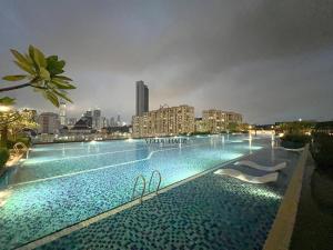 吉隆坡Sentral Suites at Kuala Lumpur Sentral by Veedu Hauz的一座在晚上与城市相连的大型游泳池