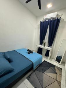 亚娄MK Homestay Perlis的一间卧室配有蓝色的床和蓝色窗帘