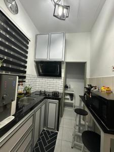 亚娄MK Homestay Perlis的厨房配有白色橱柜和黑色台面