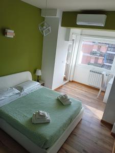 罗马Il Coriandolo 2的绿色卧室设有床和窗户