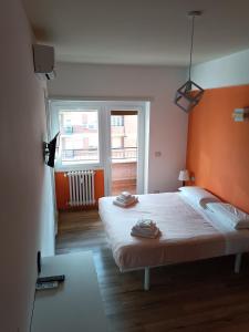 罗马Il Coriandolo 2的一间卧室配有一张带橙色床头板和窗户的床。