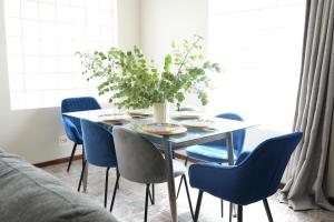 开普敦The Dahlia的一张带蓝色椅子和花瓶的餐桌