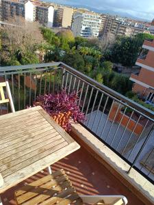 罗马Il Coriandolo 2的阳台配有木凳、桌子和鲜花