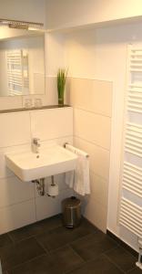 比登科普夫Lahn Hotel的白色的浴室设有水槽和镜子
