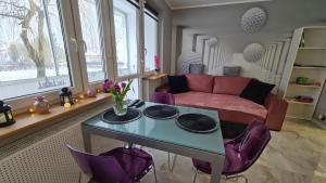 马佐夫舍地区新庄园Modlin Deluxe Suite的客厅配有桌子和紫色椅子