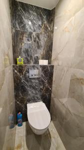 马佐夫舍地区新庄园Modlin Deluxe Suite的一间带卫生间和黑色大理石墙的浴室