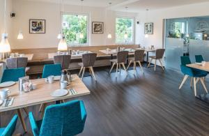 比登科普夫Lahn Hotel的餐厅设有木桌和蓝色椅子