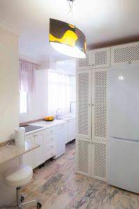 塞维利亚SJE - Shiny apartment close to the river的厨房配有白色橱柜和白色冰箱。
