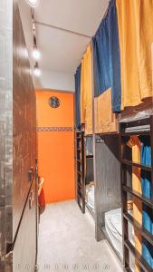 Huxi澎湖 玩聚背包民宿的客房设有许多橙色和蓝色的双层床。