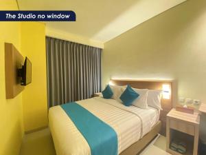 纳闽巴霍Zasgo Hotel的配有蓝色枕头的床的酒店客房