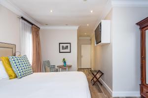 约翰内斯堡科里柯精品酒店的卧室配有白色的床和电视。
