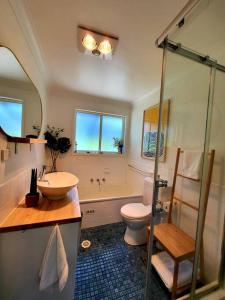 美德罗巴斯The Yellow Koala - Vibrant Home in Medlow Bath的一间带水槽、卫生间和淋浴的浴室