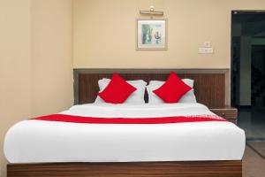 大吉岭OYO Hill Grand Himalaya的一间卧室配有红色枕头的床