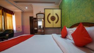 乌代浦Pax in hotel的一间卧室配有一张带红色枕头的大床