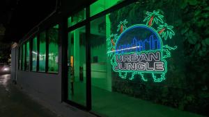曼谷Urban Jungle Hostel的建筑物窗户上的 ⁇ 虹灯标志