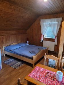 特尔乔夫Penzión Kubo的木制客房内的一间卧室,配有一张床