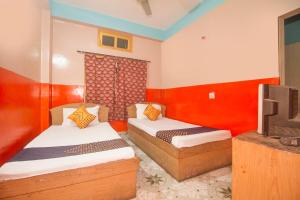 Alīpur DuārOYO Hotel Chitra的一间设有两张床和一台电视的房间