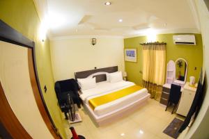 AroRemzy Hotel & Suites, Olomore的一间卧室配有一张带黄色和白色枕头的大床