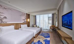 成都成都武侯渝江皇冠假日酒店的酒店客房设有两张床和一台平面电视。